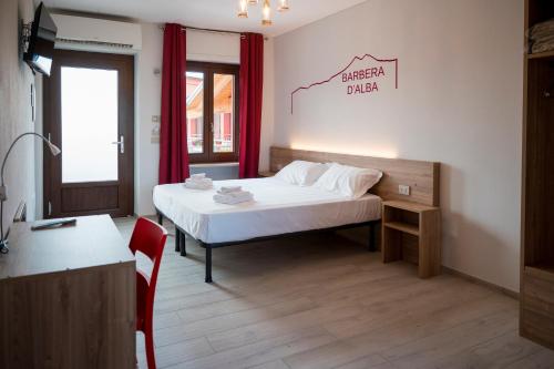 1 dormitorio con cama, mesa y escritorio en Vino e Turismo, en San Defedente di Cervasca