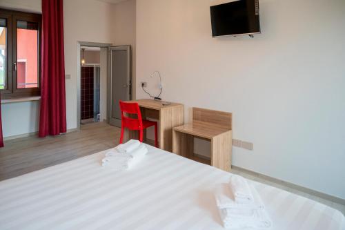 a bedroom with a bed and a desk and a red chair at Vino e Turismo in San Defedente di Cervasca