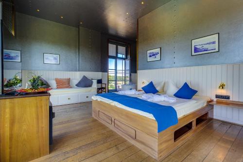 a bedroom with a large bed with blue pillows at Hotel Dömitzer Hafen in Dömitz