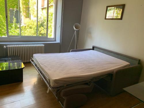 a hospital bed in a room with a window at Grand studio tout confort sur cour in Champagnole
