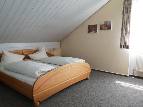 a bedroom with a wooden bed with white pillows at Pension Marcus in Bad Gögging