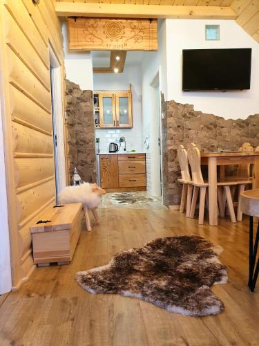 uma sala de estar com uma parede de pedra, uma mesa e uma televisão em Apartament w Zagrodzie em Frydman
