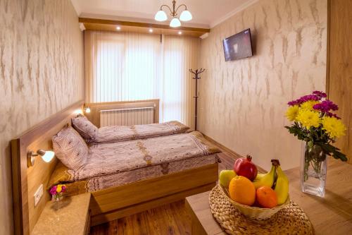 1 dormitorio con 1 cama y un plato de fruta en una mesa en Trite Bora Guest House, en Narechenski Bani