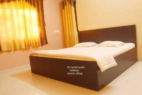 a large bed in a bedroom with a window at Orchid Anant Holidays in Alibaug