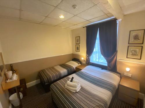 a hotel room with two beds and a window at Grange House Hotel in Blackpool