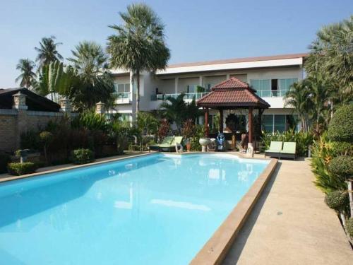 a large blue swimming pool in front of a building at Sumali Villa in Sing Buri