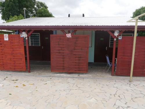 a red building with red doors in front of it at Les Gîtes De L'union in Les Abymes