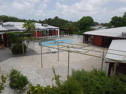 a large swimming pool with a tennis court in front of a building at Les G&icirc;tes De L'union in Les Abymes