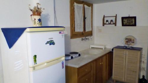 a kitchen with a white refrigerator and a counter at panormos studio in Panormos
