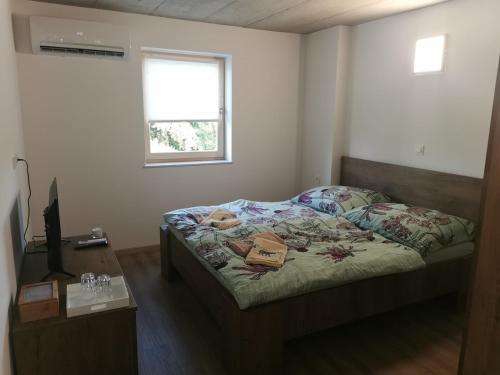 1 dormitorio con cama, escritorio y ventana en Sobe, Rooms B&B - Vina Kauran en Zgornji Jakobski Dol