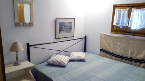 a bedroom with a bed and a lamp and a mirror at panormos studio in Panormos