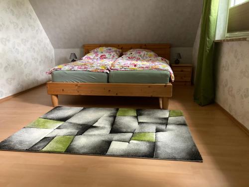 a bedroom with a bed and a rug on the floor at Haus Wald und Wiese Wohnung Wiese in Ehndorf