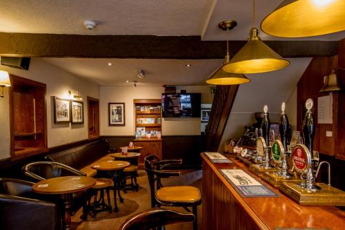a bar in a restaurant with tables and chairs at Craven Heifer Ingleton in Ingleton 