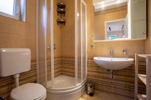 a bathroom with a shower and a toilet and a sink at Happy Apartments Baška in Baška