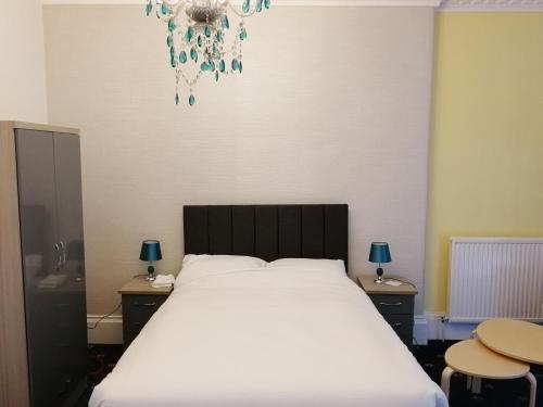 a bed room with a white bedspread and a white wall at The Cat Inn in Egremont