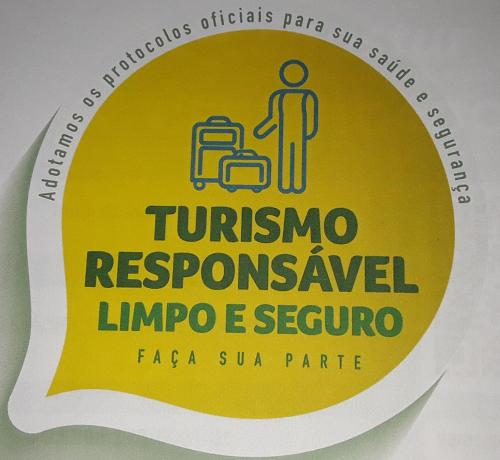 a sign for a restroom with a man with a suitcase at Recanto das Flores Lofts - Ilha Grande Rj in Abraão