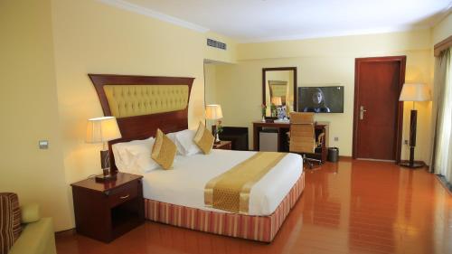 een hotelkamer met een groot bed en een bureau bij Inter Luxury Hotel in Addis Ababa