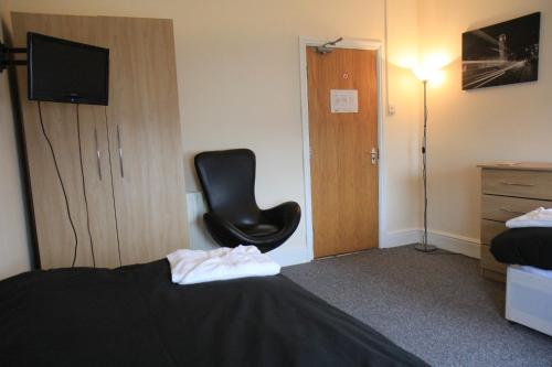 Habitación de hotel con silla y cama en Clifton arms, en Liverpool