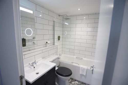 a bathroom with a sink, toilet and bathtub at Ben Wyvis Hotel in Strathpeffer