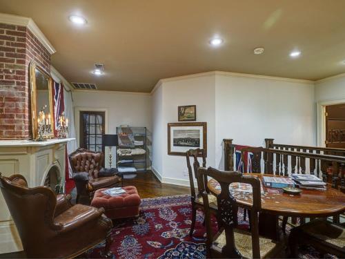 uma sala de estar com uma mesa e uma lareira em The English Merchant's Inn em Waxahachie