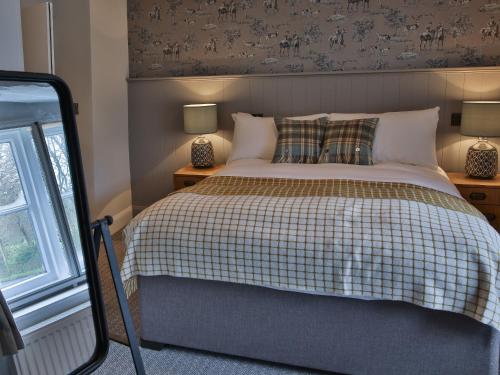 a bedroom with a bed and two lamps and a window at The Exeter Inn in Bampton