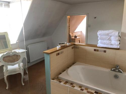 a bathroom with a large tub and a mirror at Deeping Stage in Market Deeping