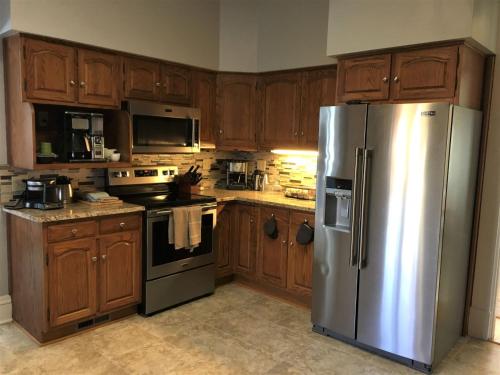 a kitchen with wooden cabinets and a stainless steel refrigerator at The Doctor's Inn in Oxford