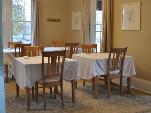een eetkamer met witte tafels en stoelen bij The Doctor's Inn in Oxford