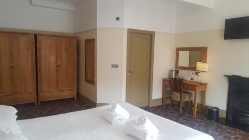 a bedroom with a bed and a desk and a fireplace at The Dolphin Hotel in Whitby