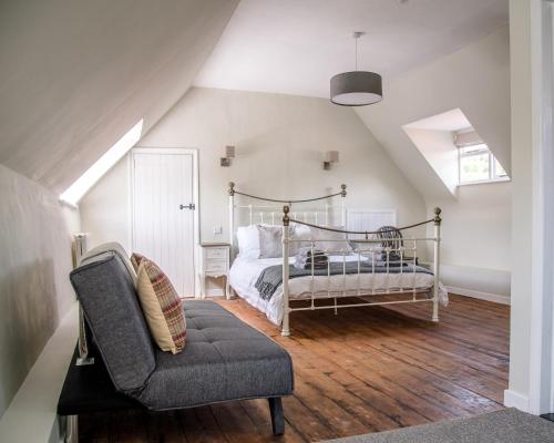a attic bedroom with a bed and a chair at The Golden Key in Snape