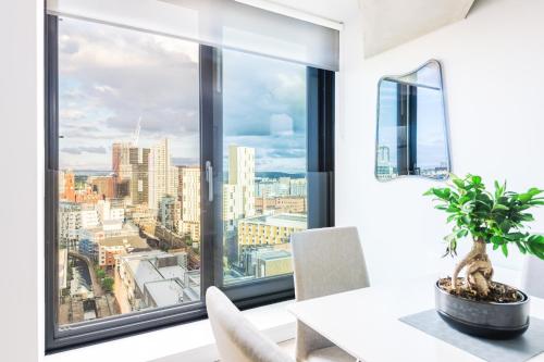 a dining room with a window view of the city at Hilltop Serviced Apartments - Deansgate in Manchester