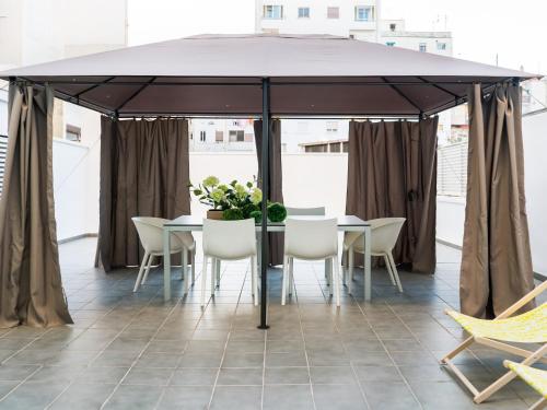 a tent with chairs and a table with flowers on it at Flat El Porto - families only, no groups in Valencia