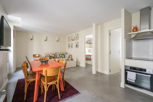 une cuisine et une salle à manger avec une table et des chaises dans l'établissement Elegant and Modern Parisian Charm, à Paris