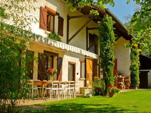 une maison avec une table et des chaises dans la cour dans l'établissement Le Domaine du Plantier, à Saint-Hilaire-de-la-Côte