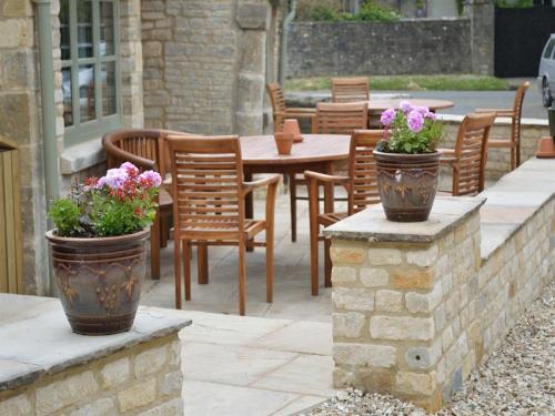 two pots of flowers sitting on a stone wall at The Plough Inn in Cheltenham