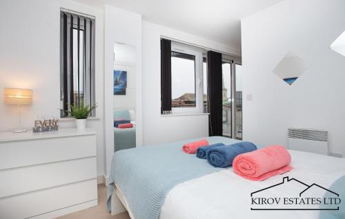 um quarto com uma cama com toalhas cor-de-rosa e azul em Poseidon Apartment - 1 Bed Flat - Heart of Town em Southampton