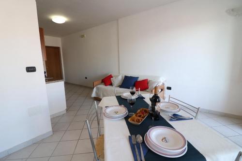 a living room with a table with plates on it at Casa vacanze Vanessa in Salento 5 posti in Otranto