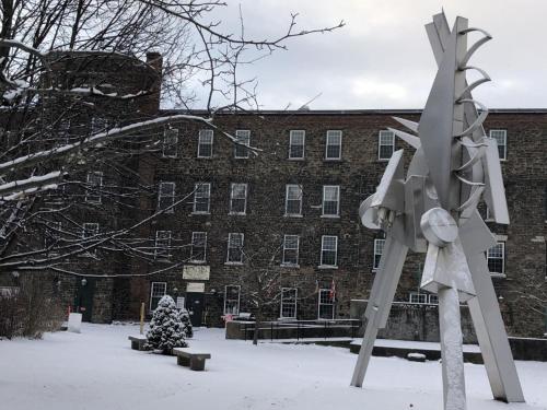a sculpture in the snow in front of a building at The Inn at Stone Mill in Little Falls