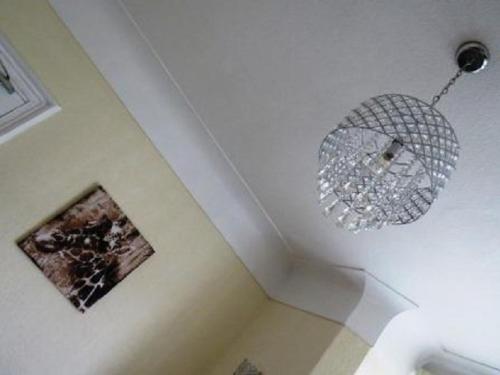 lampadario pendente appeso a un soffitto in una stanza di The Heidi Bed & Breakfast a Southport