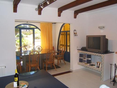 a living room with a tv and a dining room at Villa Shangri La Family in Colonia de Sant Pere