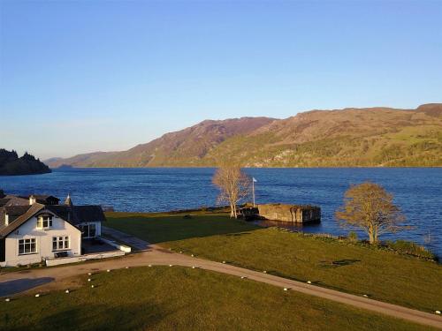 a house on the shore of a body of water at Cabins at Old Pier House in Fort Augustus