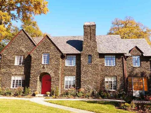een groot bakstenen huis met een rode deur bij The Manor on Front in Harrisburg