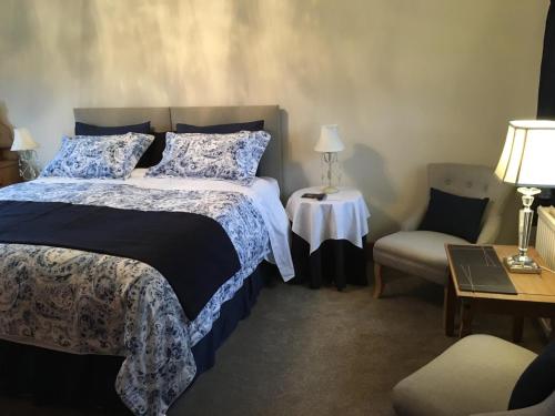 a bedroom with a bed and a table and a chair at Primrose Cottage in Norwich
