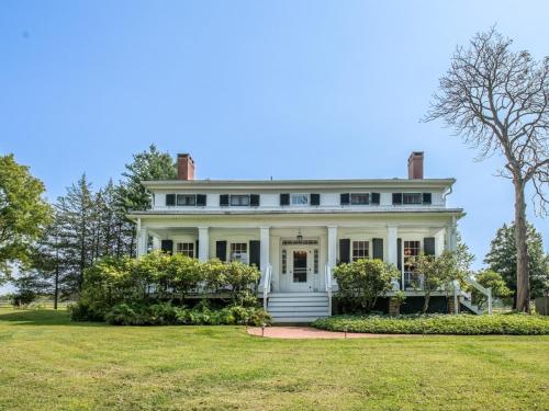 uma grande casa branca com um grande quintal em The Neighbour House B&B em Long Valley