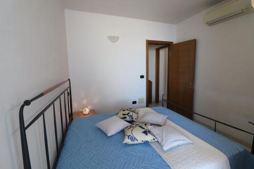 a bedroom with a bed with blue sheets and pillows at Casa vacanze Vanessa in Salento 5 posti in Otranto