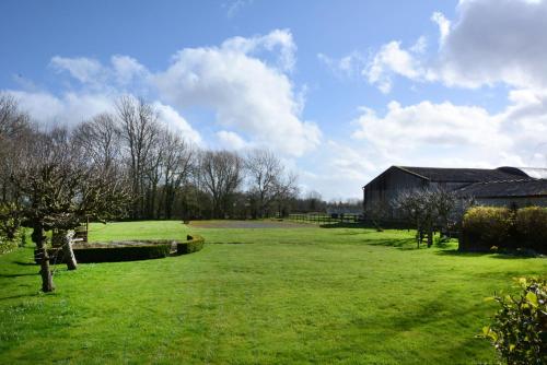 zielone pole ze stodołą i budynkiem w obiekcie The Old School w mieście Bicester