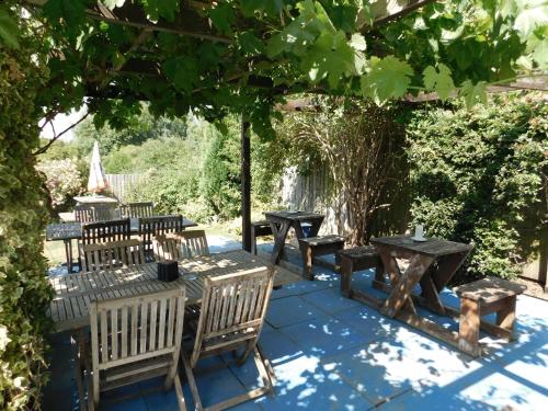 Sulgrave的住宿－The Star Inn，一组野餐桌和树下的长椅