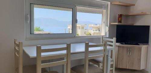una stanza con un tavolo e due sedie e una finestra di Redsun Apartment a Vlorë