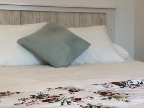 łóżko z 2 poduszkami i kocem z kwiatami w obiekcie Alma House w Porto Cristo