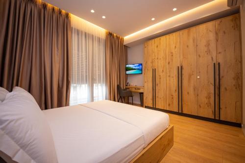 Schlafzimmer mit einem Bett und einem Schreibtisch mit einem TV in der Unterkunft Central Chic Apartments in Tirana